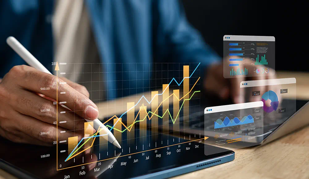 A business man typing on his tablet with a steno pad, a chart glowing above it.