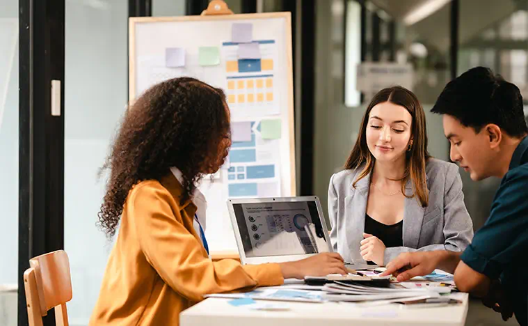 Three marketing people looking over a presentation and making changes.