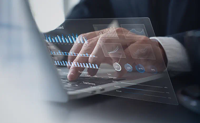 A business man types on a laptop with a bar chart superimposed on the image.