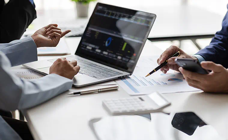 Financial Lease Analysis Two business people discuss strategy over a laptop in a modern office.