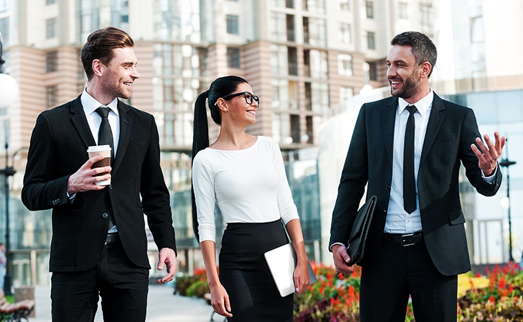 Three business people walking along the street.