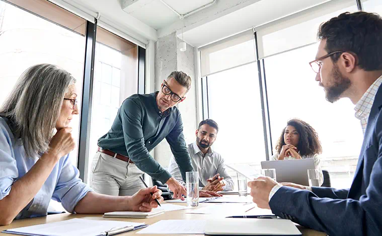 A team of people talking in a meeting room.
